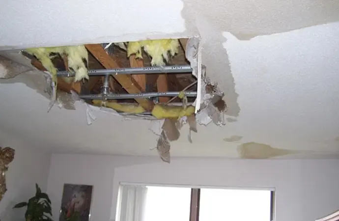 Water-damaged ceiling and attic under a leaking roof after a Louisiana storm